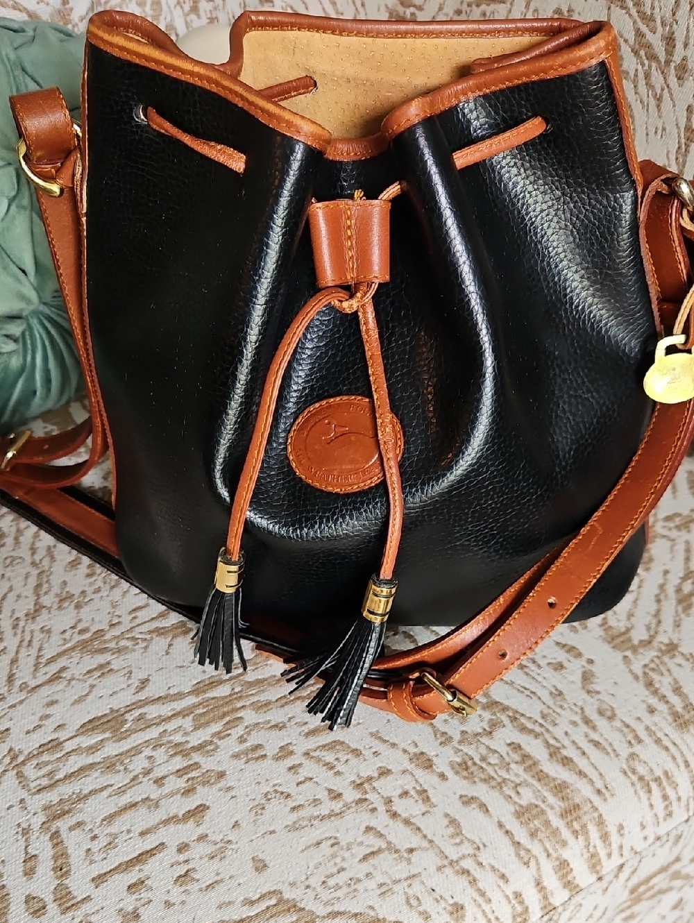 Dooney & Bourke Black with Tan Trim Pebbled Leather Drawstring Bucket Bag